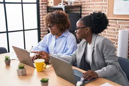 Two women working on a laptop
