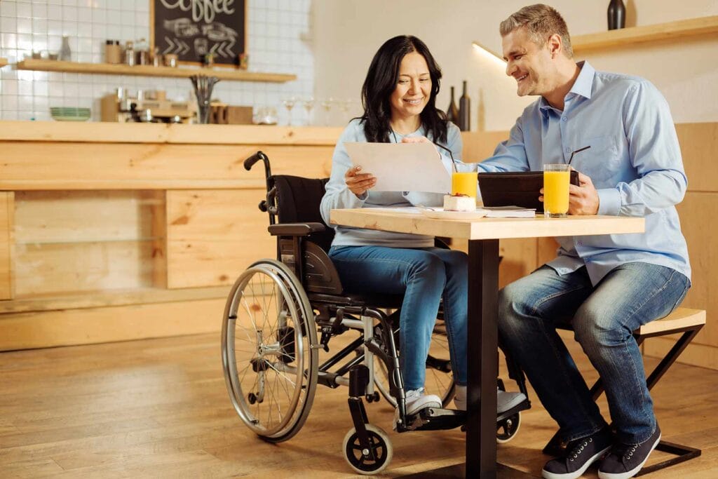 Woman in wheelchair chatting with male colleague