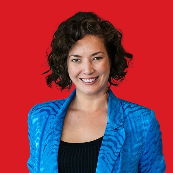 A headshot of Alanna Kamp in a red background