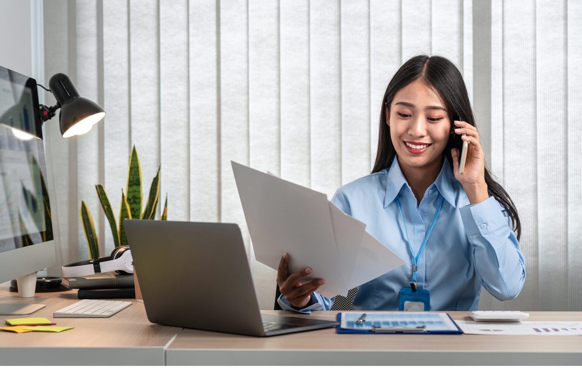 woman on phone smiling at desk