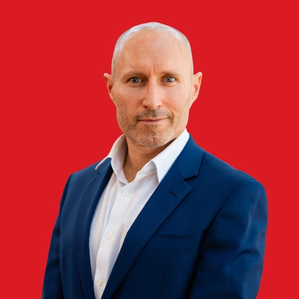 A headshot of David MacLennan in a red background