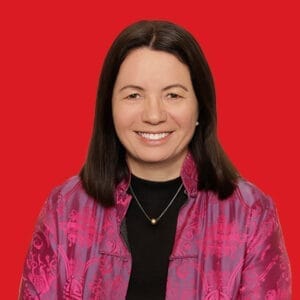 A headshot of Geraldine Chin Moody in a red background