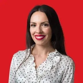 A headshot of Vicky Arachi in a red background
