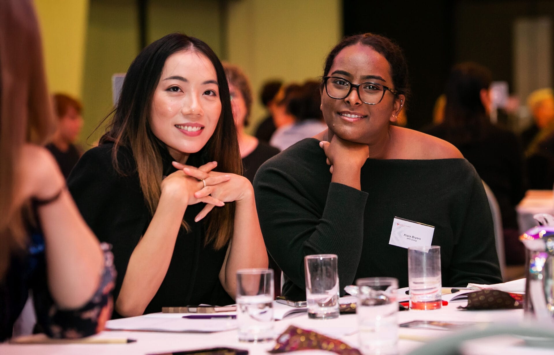 Women smiling at the symposium