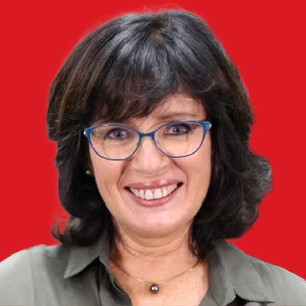 A headshot of Suzi Finkelstein in a red background