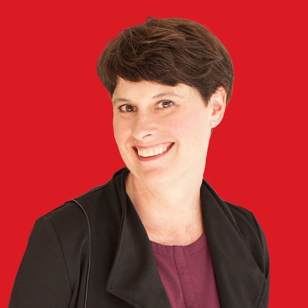 A headshot of Janet Horton in a red background