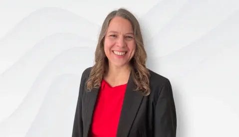 A head shot of Karen Surmon smiling and a red background