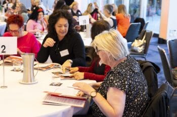 Participants sitting down at a table in the Melbourne Symposium